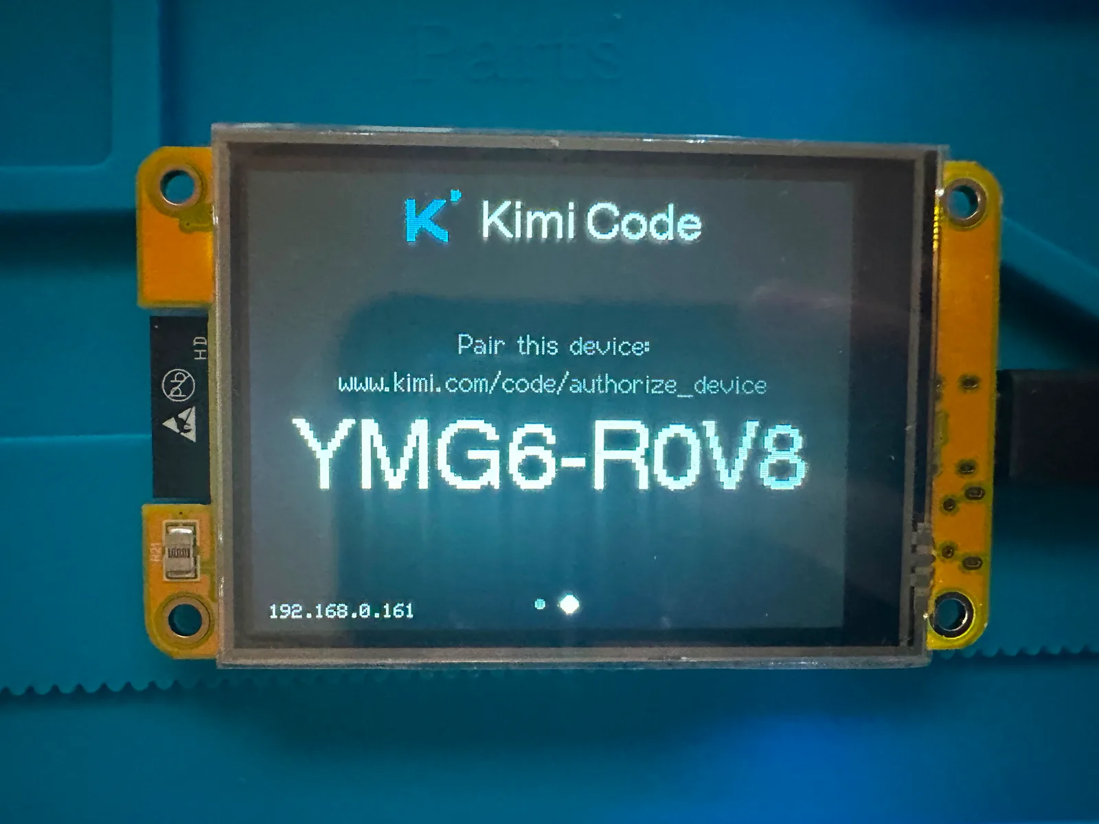 The pairing screen: a Kimi Code device code, YMG6-ROV8, with the approval URL above it. It is drawn by the provider's own connect() screen, which the display only reaches while the provider's mode is Waiting.